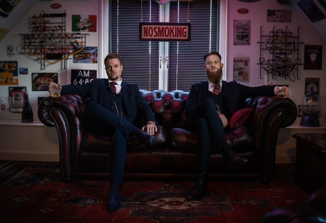 De Whisky Boys op een leren bank met whiskyglazen